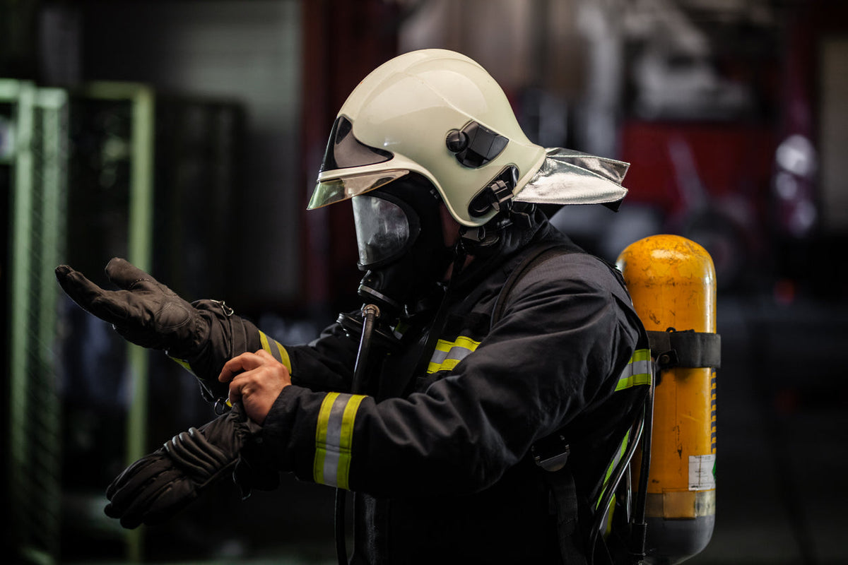 Firefighter pulling on NFPA 1971 certified structural firefighting gloves