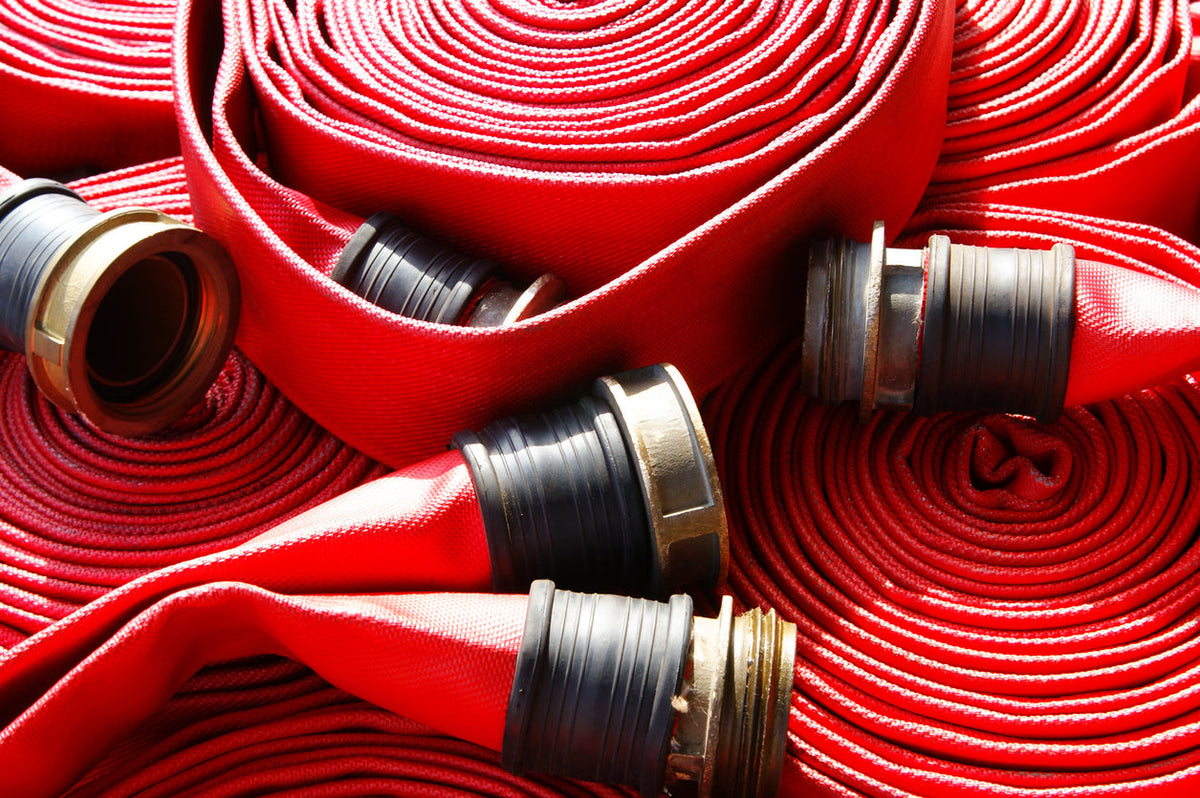 Rolled red fire hose with NST threaded couplings