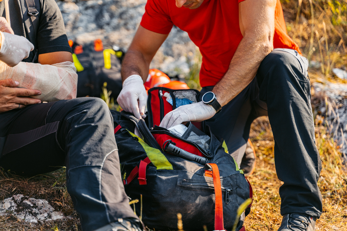 Wildland firefighter packing a red gear bag outdoors